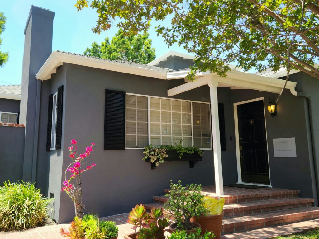 Exterior stucco house with gray/black walls and white trim in sherman oaks