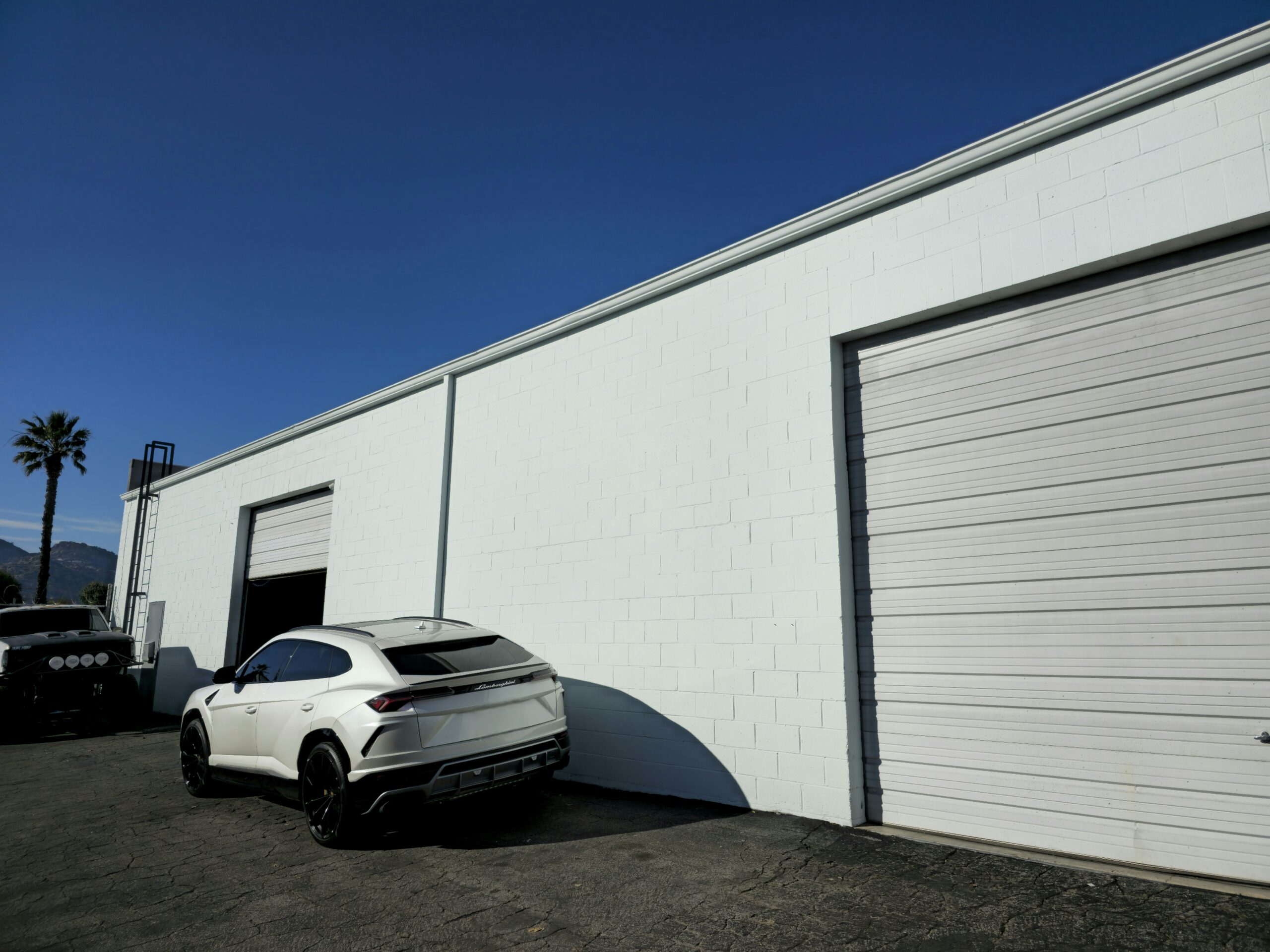 A commercial car/mechanic shop with exterior white wall freshly painted and clean.