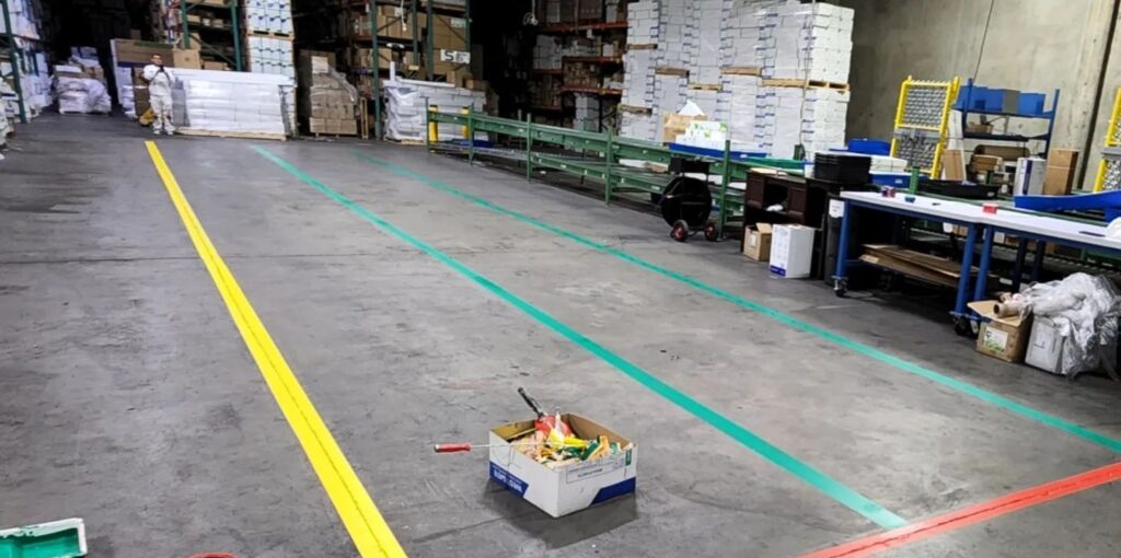 Industrial safety line painting in a warehouse.